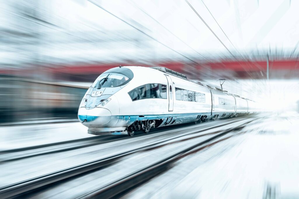 Train rides at high speed in winter around the snowy city industrial landscape