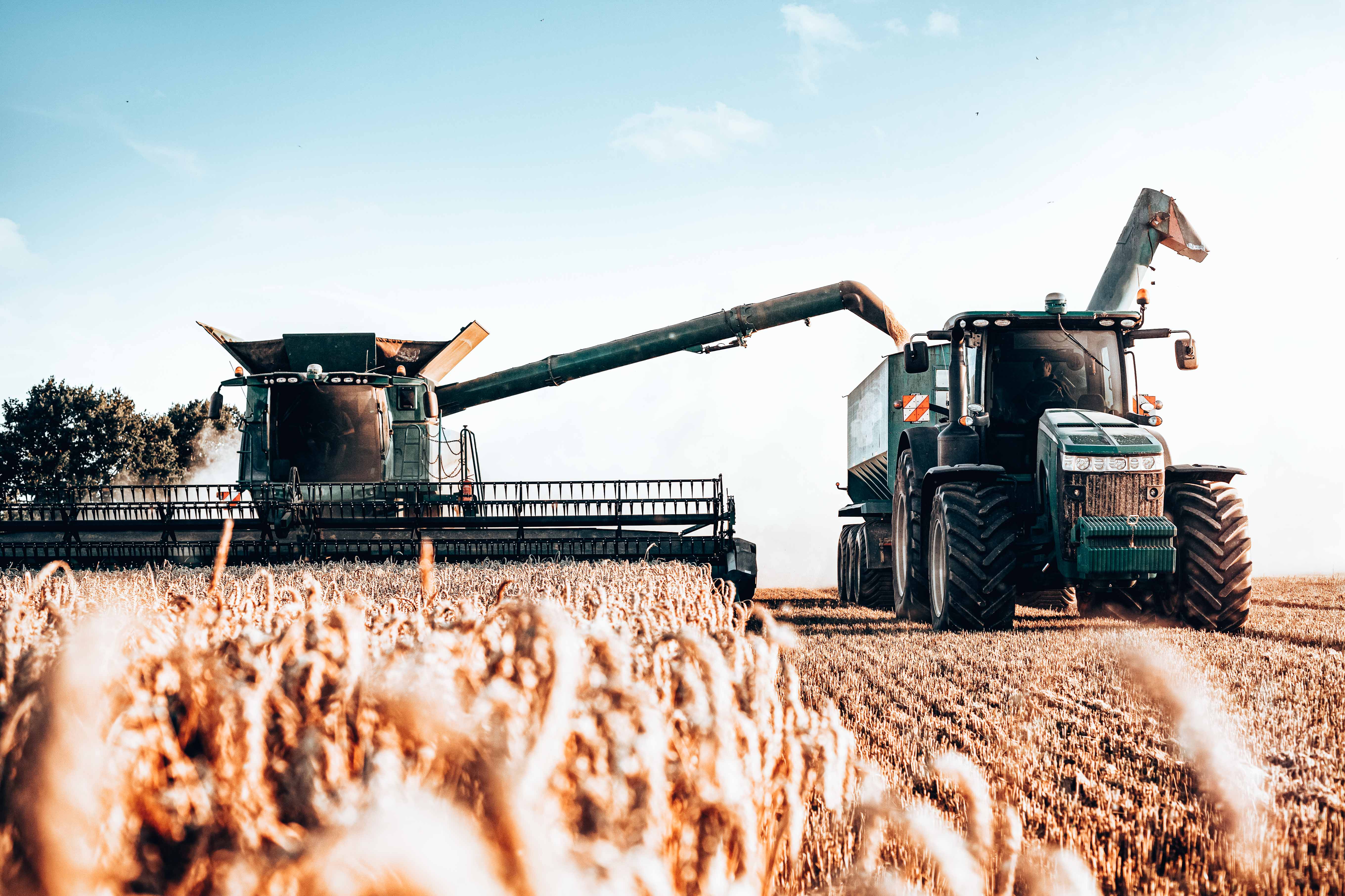 large farming equipment harvesting crop in an agriculture field