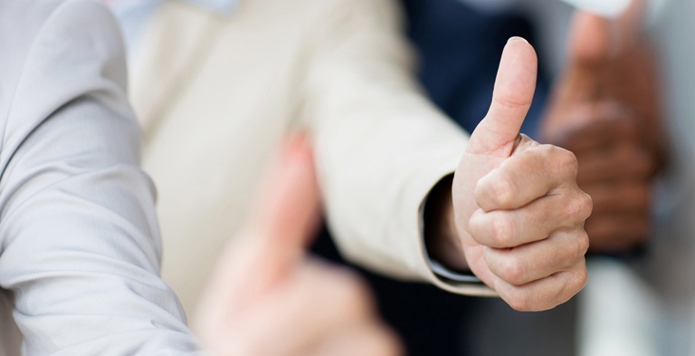 K.O.K. employees gesturing a thumbs up in the workplace